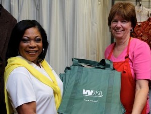 Michelle Clark, left, provides Janene Freitas reusable bags for Assistance League customers without their own.