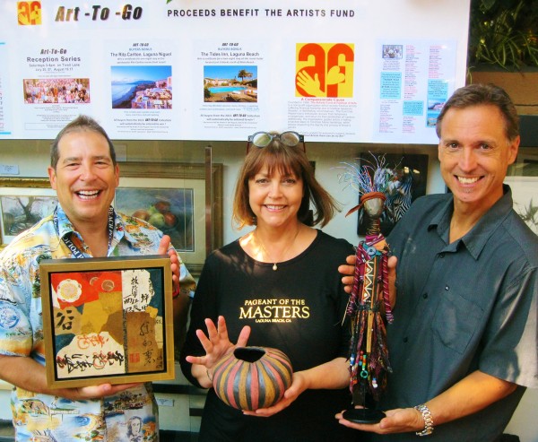 Larry Lee, Anita Mangels and Lance Heck with items set for auction Saturday, Aug. 31 from 1:30-3 p.m. during fundraising for the Artists Fund at the Festival of Arts, 650 Laguna Canyon Rd.