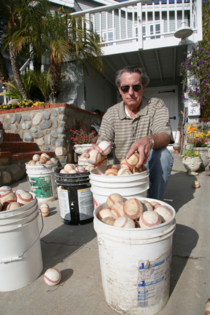Stephen Crawford with the buckets of homerun balls he and his St. Ann’s Drive neighbors have accumulated over several seasons. Photo by Jody Tiongco.