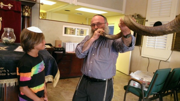 Rabbi Eli Goorevitch demonstrates sounding the shofar, a herald of the new year.