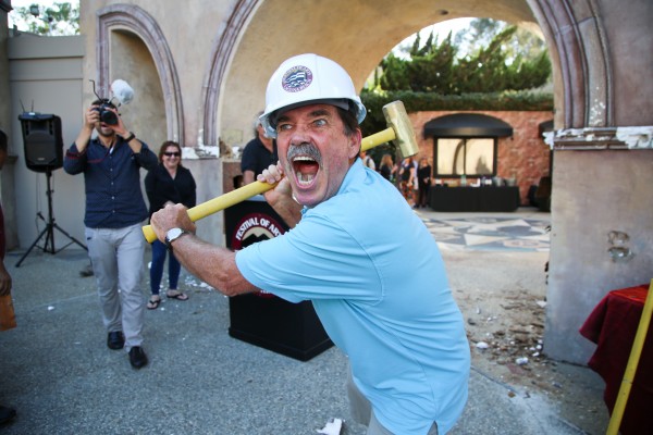Laguna Beach artist and Festival of Arts exhibitor Pat Sparkuhl wields a sledge-hammer with relish to start the demolition of the Festival of Arts’ entry. Photos by Jody Tiongco.