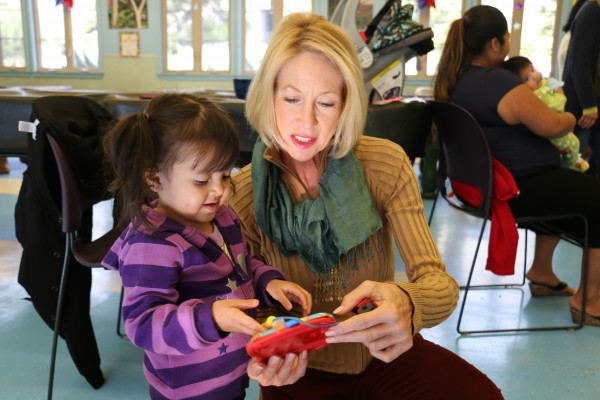 Mary Schmidt, right, the newly appointed executive director of the Cross-cultural Council visits with a daughter of an English learner at the La Playa Center in the Boys and Girls Club.