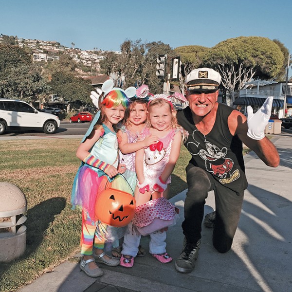 Before setting out on the Laguna Beach Parents Club kiddie parade, 4-year-olds, from left, Maya, Brooklyn, and Ashtyn get a special send-off from Laguna Beach greeter, Michael Minutoli. Photo courtesy of Tommy Donnelly 