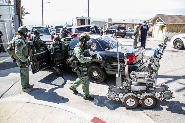 A robot and bomb squad prepare to enter Casa del Camino hotel.