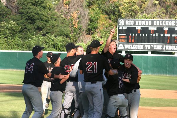 Will McInerny, with hand raised, is mobbed by his teammates after securing the final out on a strikeout.