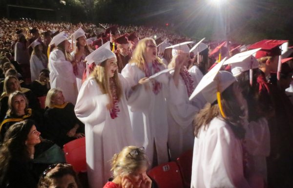 Graduating students pretend they are riding a roller coaster during the ceremony. 