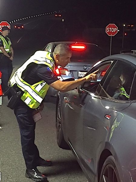 Corporal Darrel Short uses the nystagmus test to detect if a motorist is suspected of drunk driving at a checkpoint near Aliso Beach on Sunday, May 29. Photo courtesy of LBPD.