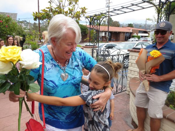 Heidi Knoff receives hugs and flowers at her retirement party at the Laguna Beach Woman’s Club after operating a pre-school for four decades. Photo by Marilynn Young 