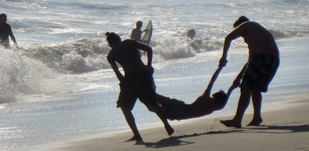 Friends can’t resist time-honored shenanigans on Bluebird Canyon Beach. Photo by Marilynn Young.