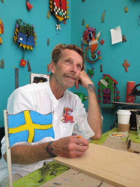 Artist Nikolai Erngren works on a clock in his booth 