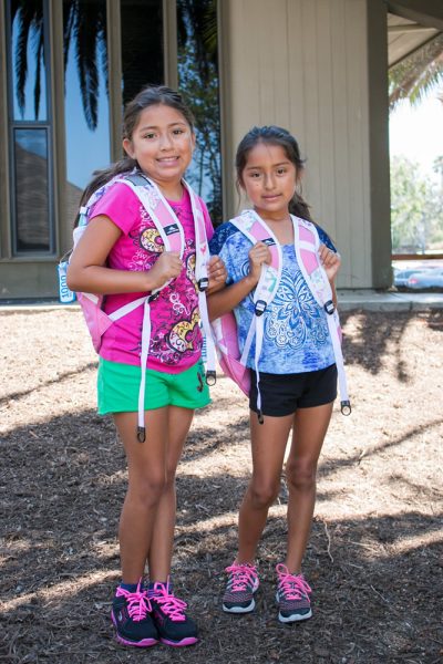 Rebeca Gonzalez, 10, and sister Belen, 8, try out the new backpacks supplied by the Woman’s Club of Laguna Beach. 