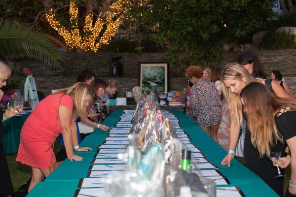 : Guests check out the auction items at the Girls Night Out fundraiser at the home of Holly Wilson who opens her house each year for the Girls Night Out fundraiser. 