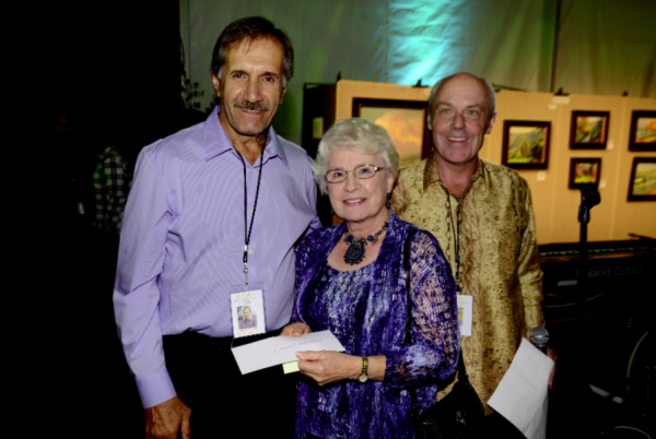  Yvonne Boseker, center, honors her late husband by offering the Dr. Edward H. Boseker award to artist Ebrahim Amin, left, at the 2013 Plein Air Invitational with president Greg Vail, right. 