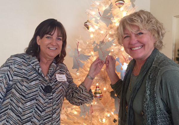 Renae Hinchey, left, and Debbie Neev select the name of a family for water district employees to adopt this Christmas during a recent Woman’s Club lunch. Members helped chip in support for Sande St. John’s adopt-a-family initiative.