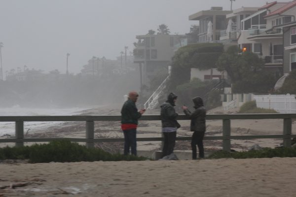 Spectators watch the churning waves at Aliso Beach.