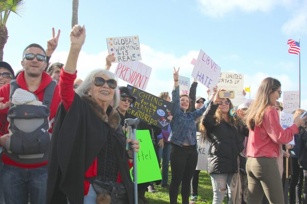 The women’s march in Laguna Beach cut across generations. Jan Young, of Lake Forest, stakes out spot separate from the crowd with her sign of support for the civil rights leader. Former Mayor Jane Egly joins the march. 