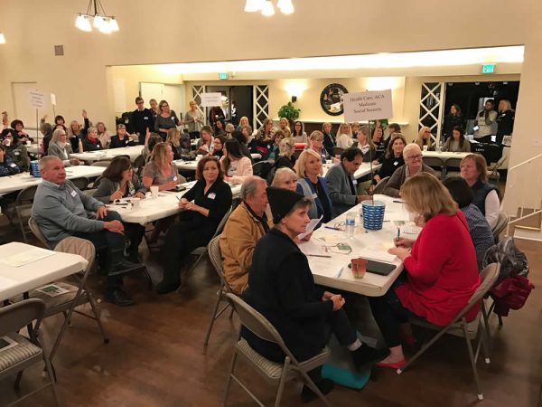 At the inaugural huddle of Laguna Unites, members self-select tables with talking points about issues and convey their concerns via post cards to elected representatives. Photo courtesy of Tad Heitmann.