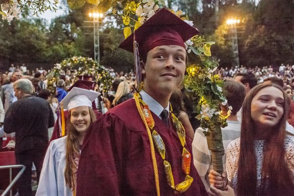 Soon-to-be graduates Clair Stone, left rear, and Dylan Soloff, center, take part in a Laguna Beach High School tradition, ascending into the Irvine Bowl commencement ceremony through flowered arches. Photo by Mitch Ridder.