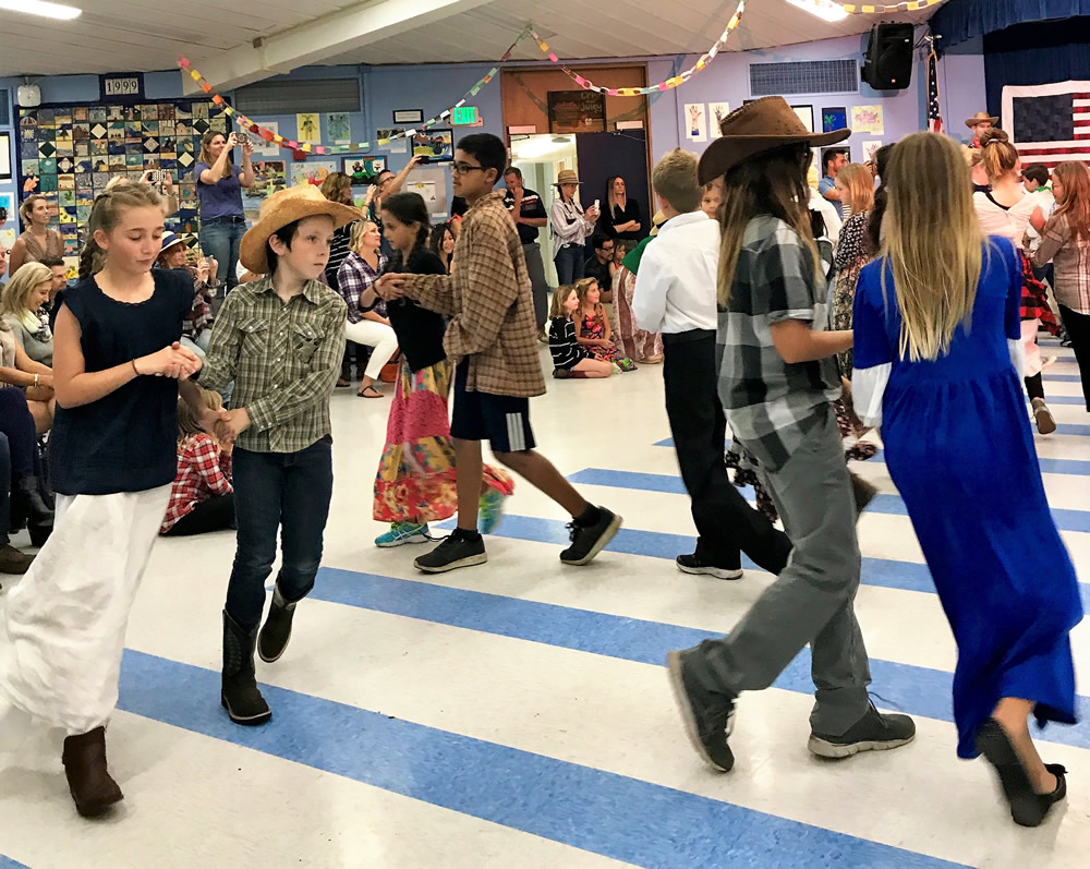 Chase Benson and Kate Storke promenade around the floor with their fifth grade classmates.