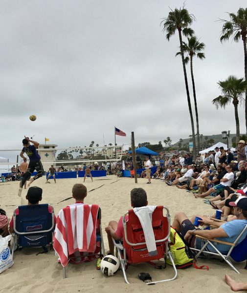 Spectators at the Laguna Open on Sunday, June 4, watch as Mark Burik launches a jump serve at the team of Mike Brunsting and Chase Frishman. Photos by Amy Orr.