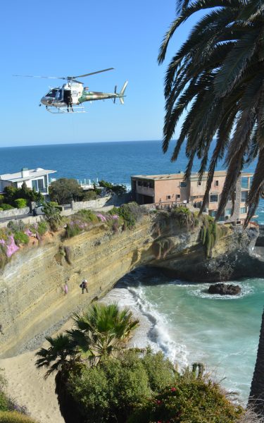 Sheriff’s deputies airlift out an unconscious teen from an isolated cove in South Laguna, a rescue that involved three helicopters, a practice that continues to cause friction between fire fighters and sheriff’s deputies. Photo by John Thomas. 