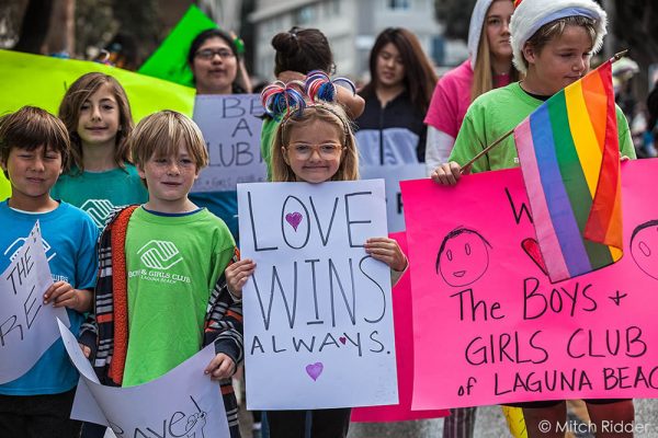 A poster held by Zoey C., 7, of Laguna Beach, center, signals the Boys and Girls Club’s ethos. Photo by Mitch Ridder.