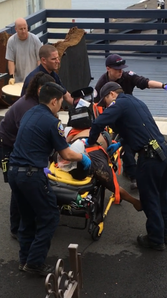 Paramedics continue to massage the heart of a worker as they prepare to transport him from a job site on Sunset Avenue. Photo courtesy of Victoria Hawlish.