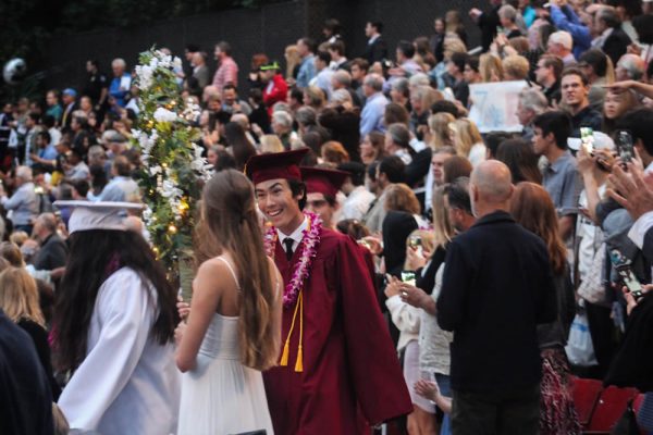 Soon-to-be graduate Jake Booth walks during the Procession of the Graduates through flowered arches, a LBHS tradition.