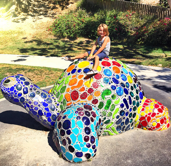 City workers are currently repairing some of the glass inserts in the well-loved Bluebird Park turtle made by Michele Taylor, part of on-going maintenance of the city’s public art collection.Photo courtesy of Sandy Toes and Popsicles blog.
