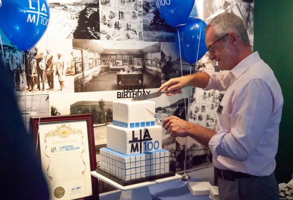 Museum Director Malcolm Warner cuts into the Laguna Art Museum’s 100th birthday cake during a celebration on Saturday, Aug. 25.